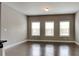 Bright living area featuring hardwood floors and a trio of windows at 1820 Cobblefield Cir, Dacula, GA 30019