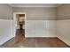 Living room with hardwood floors, wainscoting, and view into kitchen at 1820 Cobblefield Cir, Dacula, GA 30019