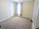 Bedroom features neutral carpet, gray walls, and a window with curtains at 1581 Shetland Pony Nw Ct, Suwanee, GA 30024
