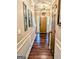 Inviting hallway featuring hardwood floors, elegant wall trim, and a stylish pendant light at 1581 Shetland Pony Nw Ct, Suwanee, GA 30024