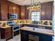Well-equipped kitchen with dark wood cabinets, granite countertops, and a center island at 1581 Shetland Pony Nw Ct, Suwanee, GA 30024