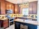Gourmet kitchen featuring stainless steel appliances, granite countertops, and a stylish island at 1581 Shetland Pony Nw Ct, Suwanee, GA 30024