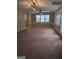 Spacious living room featuring neutral carpet, a ceiling fan, and natural light from the windows at 1581 Shetland Pony Nw Ct, Suwanee, GA 30024