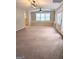Spacious living room featuring plush carpet and natural light from multiple windows at 1581 Shetland Pony Nw Ct, Suwanee, GA 30024