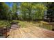 Enjoy the private backyard with a wooden deck, lush greenery, and mature trees, perfect for outdoor activities at 1252 Heritage Dr, Villa Rica, GA 30180