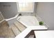 Bathroom close-up on a large soaking tub with stone tile surround, perfect for relaxation at 1252 Heritage Dr, Villa Rica, GA 30180