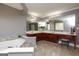Bathroom features a soaking tub and a double vanity with cherry cabinets and large mirrors at 1252 Heritage Dr, Villa Rica, GA 30180