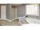 Bathroom features a shower, a soaking tub with stone detail, and a large picture window at 1252 Heritage Dr, Villa Rica, GA 30180