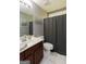 Bathroom with a brown vanity, sink and toilet with a shower and tub at 1252 Heritage Dr, Villa Rica, GA 30180