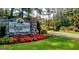 Welcoming entrance to Fairfield Plantation with stone signage, vibrant red flowers, and manicured landscaping at 1252 Heritage Dr, Villa Rica, GA 30180