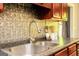 Close-up of a kitchen sink with stainless steel faucet and metallic backsplash at 1252 Heritage Dr, Villa Rica, GA 30180