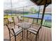 Covered wooden patio featuring a table with seating and a view of the community tennis court at 1252 Heritage Dr, Villa Rica, GA 30180