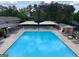 An aerial view of a community pool with a patio area, umbrellas, lounge chairs and well-kept landscaping at 1252 Heritage Dr, Villa Rica, GA 30180