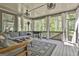 Relaxing back porch with comfortable seating, curtains, grill, and view of the wooded back yard at 608 White Cedar Ct, Peachtree City, GA 30269