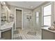 Bright bathroom featuring a dual sink vanity, tiled floors, and a glass-enclosed shower at 608 White Cedar Ct, Peachtree City, GA 30269