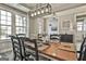 Elegant dining room with hardwood table, large windows and modern chandelier lighting fixture at 608 White Cedar Ct, Peachtree City, GA 30269
