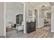 Well-lit hallway featuring paneled walls, hardwood floors, decor and a view into the adjacent sitting room at 608 White Cedar Ct, Peachtree City, GA 30269