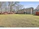 A large backyard featuring mature trees, green grass, outdoor structure, and plenty of space at 100 Rockland Trl, Sharpsburg, GA 30277