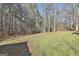 An expansive backyard featuring a well-manicured lawn, mature trees, and natural surroundings at 100 Rockland Trl, Sharpsburg, GA 30277