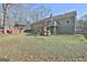 Well-maintained backyard with a covered porch, deck, mature trees, and a play area at 100 Rockland Trl, Sharpsburg, GA 30277