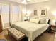 Neutral primary bedroom with large bed, bench, and windows at 100 Rockland Trl, Sharpsburg, GA 30277