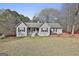 Charming single-story home featuring gray siding, black shutters, and a cozy front porch with an American flag at 100 Rockland Trl, Sharpsburg, GA 30277