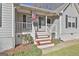 Inviting front porch with white railings, red-painted steps, potted plants and an American flag at 100 Rockland Trl, Sharpsburg, GA 30277