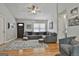 Inviting living room featuring hardwood floors, a gray sectional sofa, and a ceiling fan at 100 Rockland Trl, Sharpsburg, GA 30277