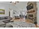 Spacious living room with hardwood floors, stone fireplace, gray sofa, and ceiling fan at 100 Rockland Trl, Sharpsburg, GA 30277