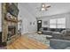 Open living space featuring a stone fireplace, hardwood floors, gray walls, and comfortable seating at 100 Rockland Trl, Sharpsburg, GA 30277