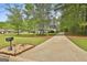 Long driveway leading to a charming home with a beautifully landscaped front yard at 225 Mapledale Trl, Sharpsburg, GA 30277