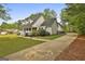 Exterior view of home showcasing a long driveway, well-kept lawn, and tasteful landscaping at 225 Mapledale Trl, Sharpsburg, GA 30277