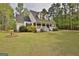 Angled view of a charming home featuring dormer windows and a well-maintained lawn and landscaping at 225 Mapledale Trl, Sharpsburg, GA 30277