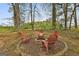 Inviting backyard fire pit area featuring Adirondack chairs, perfect for outdoor gatherings and relaxation at 225 Mapledale Trl, Sharpsburg, GA 30277