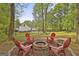 Back yard fire pit surrounded by six red Adirondack chairs at 225 Mapledale Trl, Sharpsburg, GA 30277
