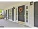 Close-up of a stylish front door with decorative wreath, sidelights, and black shutters at 225 Mapledale Trl, Sharpsburg, GA 30277