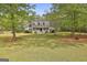 Charming home featuring a covered porch, dormer windows, and a well-manicured lawn surrounded by mature trees at 225 Mapledale Trl, Sharpsburg, GA 30277