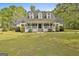 Beautiful home showcasing a covered porch,dormer windows, and a lush green lawn at 225 Mapledale Trl, Sharpsburg, GA 30277