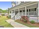 Covered front porch with white railings, steps and landscaping, showcasing a welcoming entrance at 225 Mapledale Trl, Sharpsburg, GA 30277