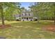 Spacious front yard showcasing a well-maintained lawn and mature trees surrounding the home at 225 Mapledale Trl, Sharpsburg, GA 30277