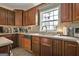 Kitchen featuring brown cabinets, a window overlooking the yard, and neutral countertops at 225 Mapledale Trl, Sharpsburg, GA 30277