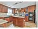 Kitchen featuring wooden cabinets, an island, stainless steel appliances and neutral countertops at 225 Mapledale Trl, Sharpsburg, GA 30277
