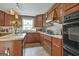 Kitchen featuring wooden cabinets, an island, stainless steel appliances and neutral countertops at 225 Mapledale Trl, Sharpsburg, GA 30277