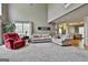 Open living room features neutral carpet, high ceilings, a comfy sofa and armchair, and lots of natural light at 225 Mapledale Trl, Sharpsburg, GA 30277