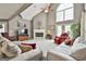 Spacious living room with a fireplace, high ceilings, neutral carpet, and natural light from the large windows at 225 Mapledale Trl, Sharpsburg, GA 30277