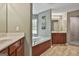 Main bathroom with separate vanities, a soaking tub, and a walk-in shower at 225 Mapledale Trl, Sharpsburg, GA 30277