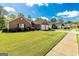 View of the front of a brick home situated on a manicured lawn and tree-lined street at 11970 Fairway Overlook, Fayetteville, GA 30215