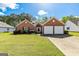 Charming brick home featuring an attached two car garage and a well-manicured lawn at 11970 Fairway Overlook, Fayetteville, GA 30215
