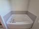 Close up of a bathtub featuring a tile surround and chrome faucet at 35 Charleston Ln, Covington, GA 30016
