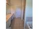 Bathroom featuring double sinks, tile floors, and a glass-enclosed shower at 35 Charleston Ln, Covington, GA 30016